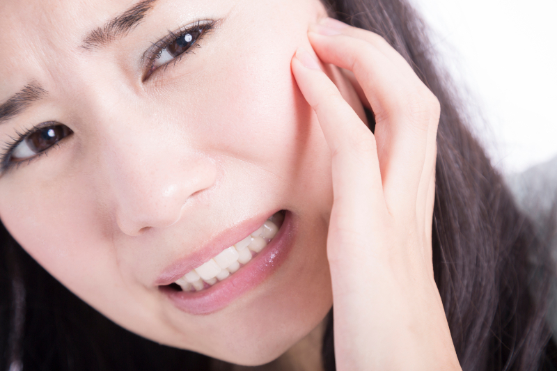 虫歯が再発して痛みを感じる女性