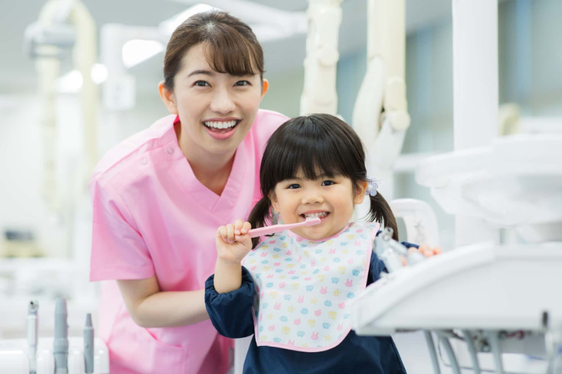 歯科医院で正しい歯磨き方法を教えてもらう女の子