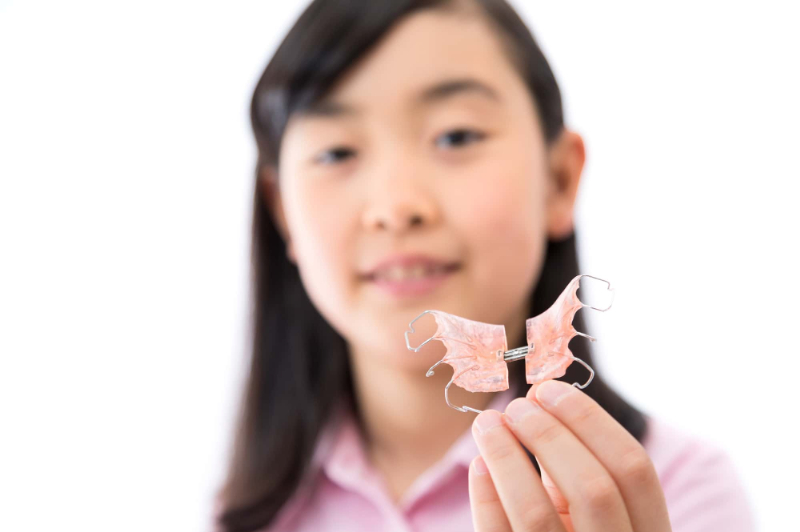 床矯正の器具を手に持った子ども