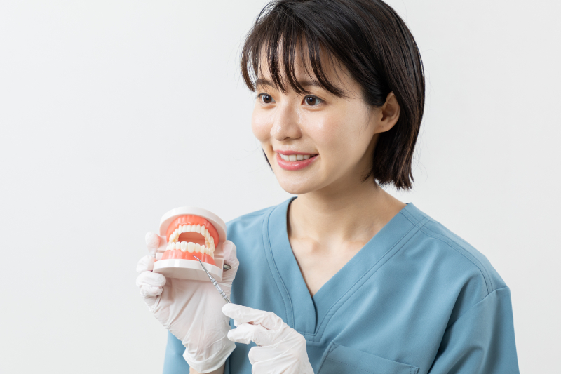 歯周病の進行を防ぐために定期検診が重要であると説明する歯科医師