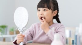自分の歯を鏡で見る女の子