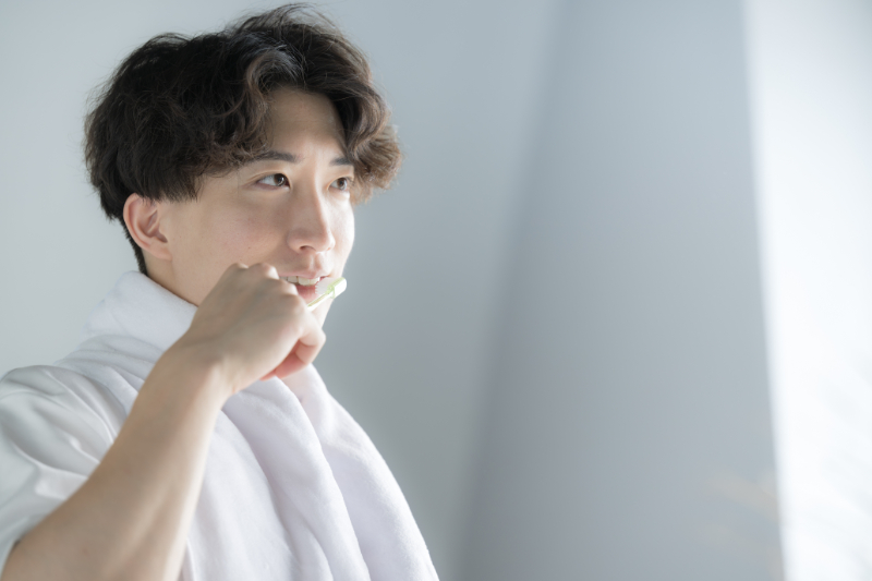 歯周病を予防するため丁寧に歯磨きをする男性