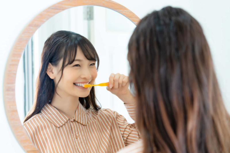 歯と歯の間の虫歯を防ぐために正しい歯みがきをする女性