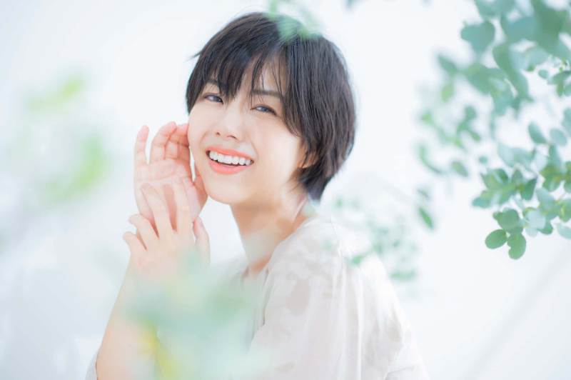 審美歯科治療で美しくなった歯で笑う女性