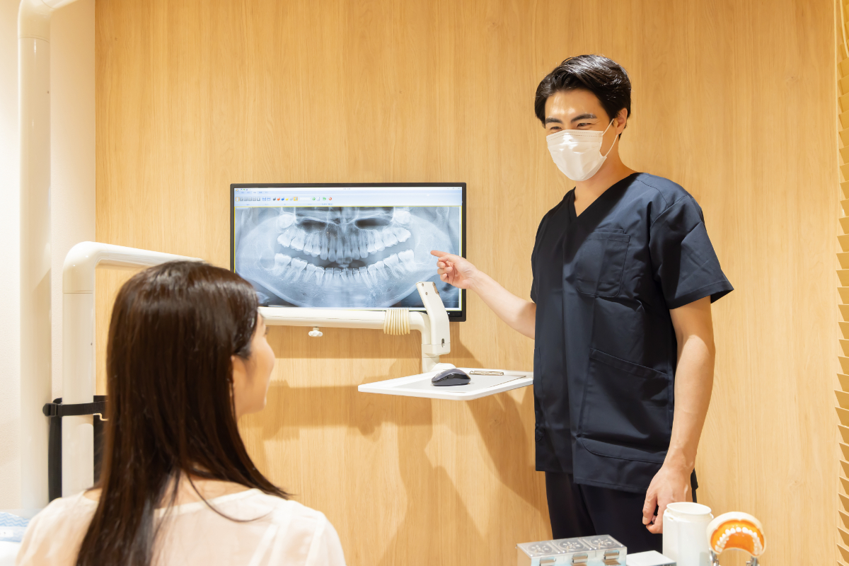 矯正治療で抜歯をする流れを説明する歯科医師