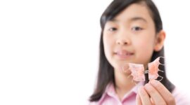 床矯正で使用する装置を持っている子供