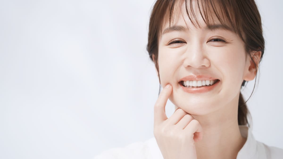 毎日のケアで健康な奥歯を指さしてほほ笑む女性